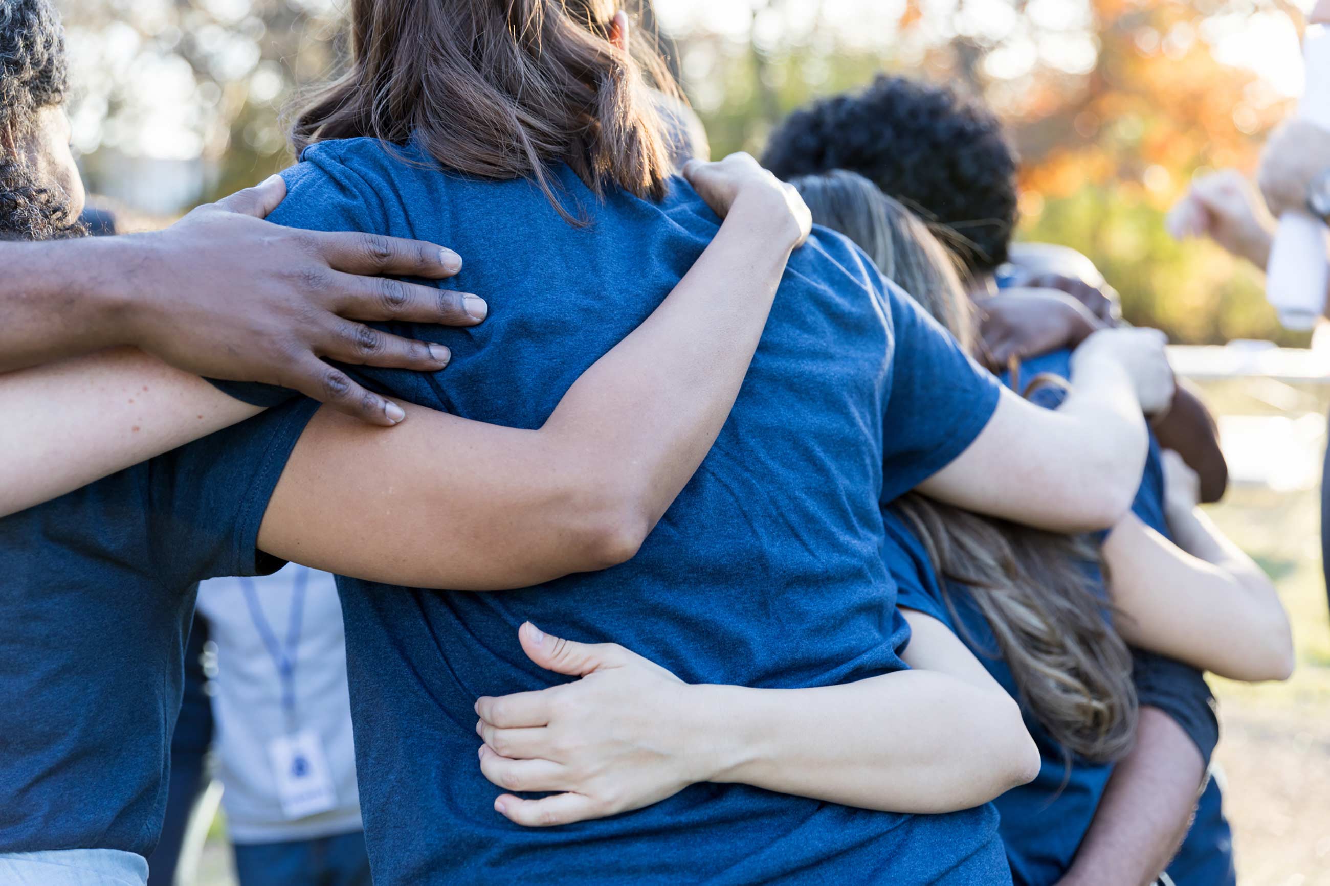 Group of young people with arms around each other