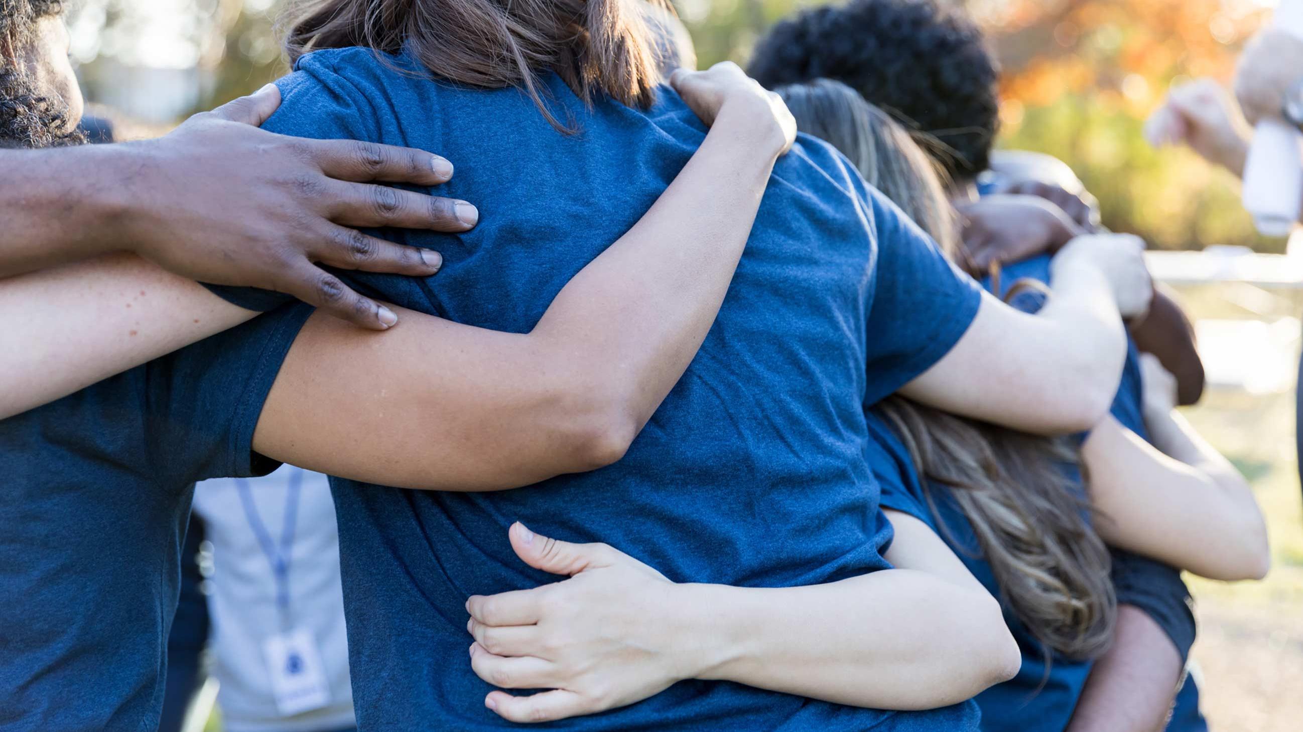 Group of young people with arms around each other