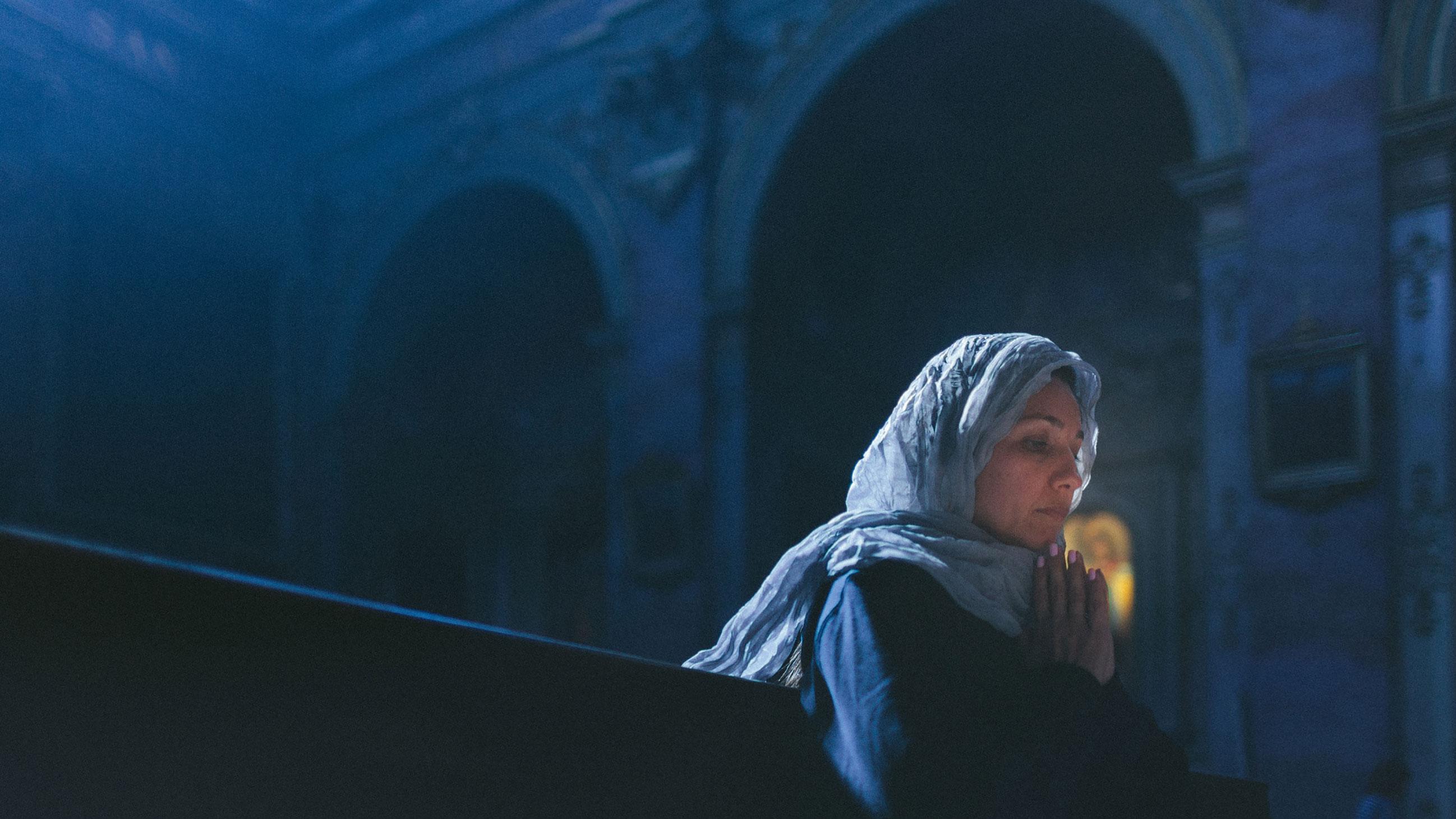 Woman with head cover alone in religious setting